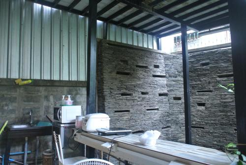 a kitchen with a counter and a brick wall at Eco House in Bangkok