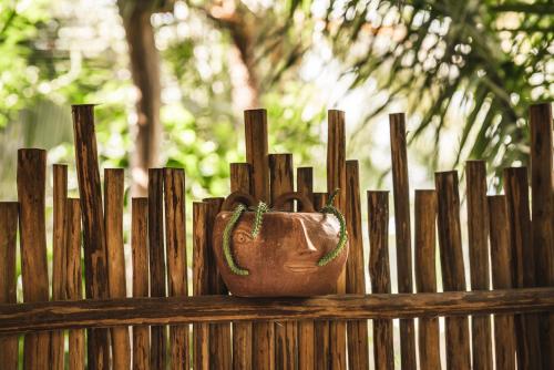 a vase sitting on top of a wooden fence at Casa Chula Hotel Boutique Frente al Mar in Tierra Blanca