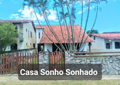 ein Schild vor einem Haus mit einem Zaun in der Unterkunft Casa sonho sonhado in São Pedro da Aldeia