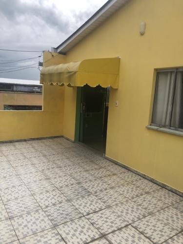 a yellow house with a door and a tiled floor at Apartamento Natureza Verde Manauara in Manaus