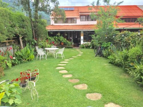 a garden with a table and chairs on the grass at Hostal Santa Clara B&B in Apaneca