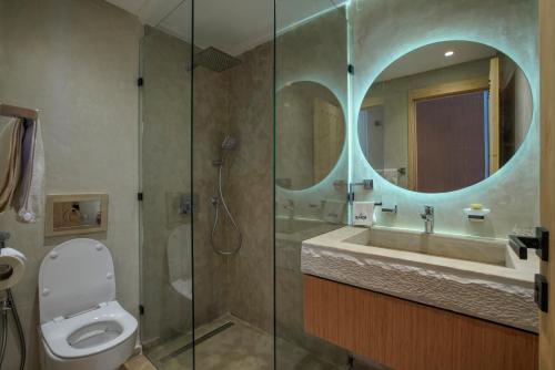 a bathroom with a toilet and a sink and a mirror at The Ranch Resort in Marrakesh