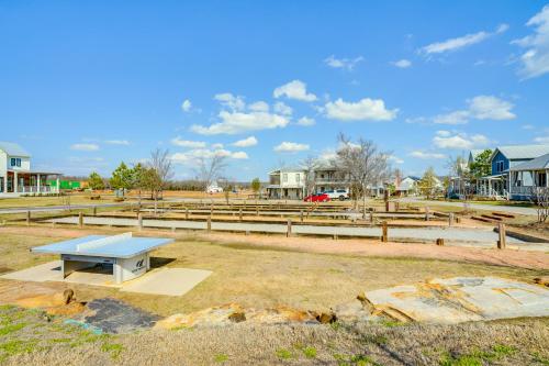 a blue picnic table in a field with houses at Carlton Landing Home at Lake Eufaula! in Eufaula