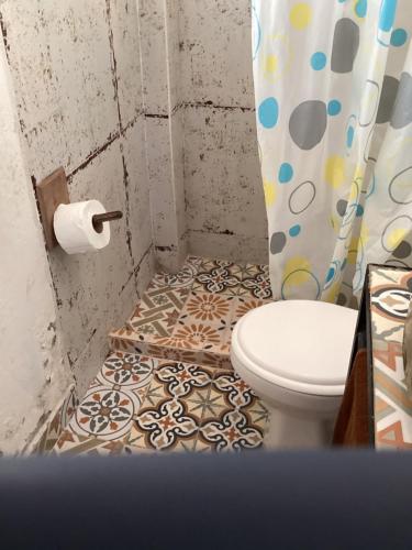 a bathroom with a toilet and a shower curtain at Las Hamacas (Hospedaje Rural) in Villamaría