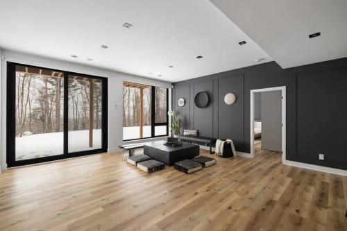 a living room with a couch and a table at Chalet Peak Tremblant: Your Mountain Escape. in La Conception