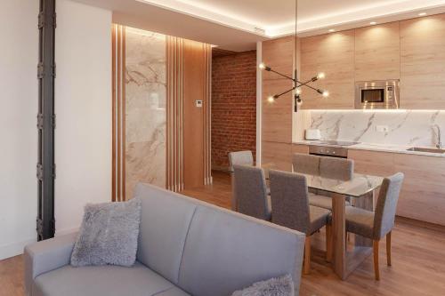 uma sala de jantar com uma mesa e um sofá em NEW, Modern and Luxurious, 3BR Apt em Madrid