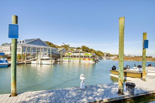a dock with boats in the water next to a house at Idyllic Murrells Inlet Home Less Than 1 Mi to Marsh Walk in Myrtle Beach