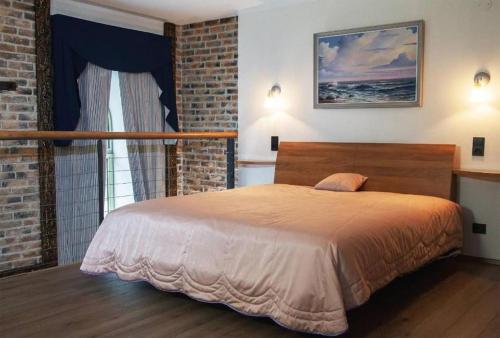 ein Schlafzimmer mit einem Bett und einer Ziegelwand in der Unterkunft Charming loft near Old Town in Tallinn