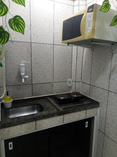 a small kitchen with a sink and a microwave at Loft a 100 metros da praia in Rio de Janeiro