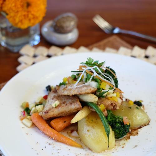 a plate of food with vegetables on a table at Alaya Dedaun Kuta in Legian