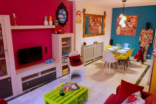 una sala de estar con una pared de color rosa y una mesa. en Apartamento POP-ART, junto a la Plaza Mayor, by My Home in Salamanca, en Salamanca