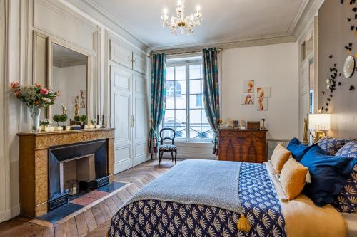 a bedroom with a bed and a fireplace at Appartement Haussmannien d’Artiste, exception, quai de Saône balcon+Parking in Lyon