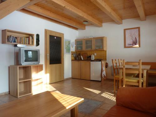 cocina y sala de estar con mesa y TV en A&B Bungalovy, en Morávka