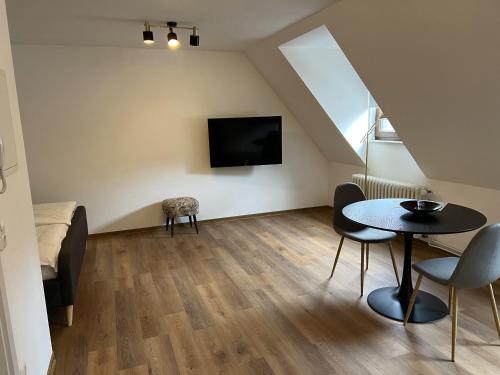 a living room with a table and a tv at Torster Ferienwohnung #8 in Hameln