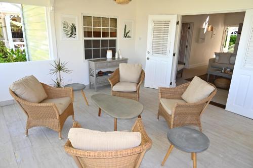 a living room with wicker chairs and tables at Little Good Harbour in Saint Peter