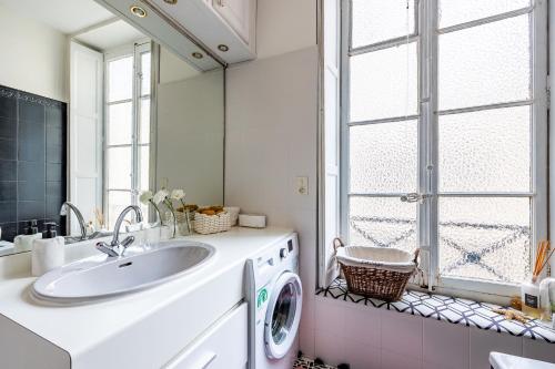 a bathroom with a sink and a washing machine at Appartement Haussmannien d’Artiste, exception, quai de Saône balcon+Parking in Lyon