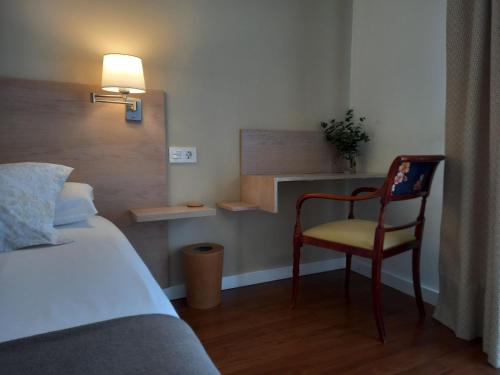 a bedroom with a bed and a chair and a lamp at Littore TORMES con Parking, AA y Piscina in Salamanca