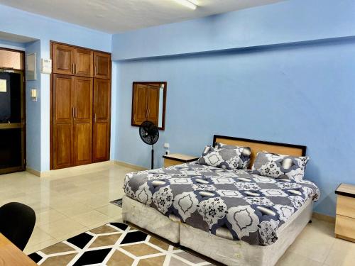 um quarto com uma cama e uma parede azul em Cliff’s Apartment em Dar es Salaam