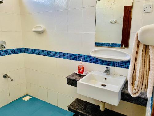 a bathroom with a sink and a mirror at Cliff’s Apartment in Dar es Salaam