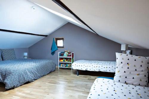 - une chambre mansardée avec 2 lits et un canapé dans l'établissement Charmant gîte Bourguignon, à Saint-Marcel