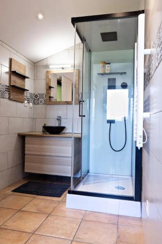 une douche avec une porte vitrée dans une salle de bain dans l'établissement Charmant gîte Bourguignon, à Saint-Marcel
