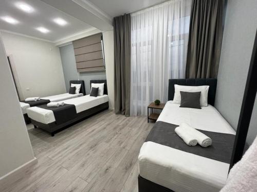 Pokój hotelowy z 2 łóżkami i lustrem w obiekcie Urban Hotel w mieście Biszkek