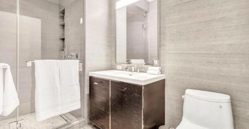 a bathroom with a sink and a toilet and a mirror at Lovely 2 Bedroom Apartment in NYC! in New York