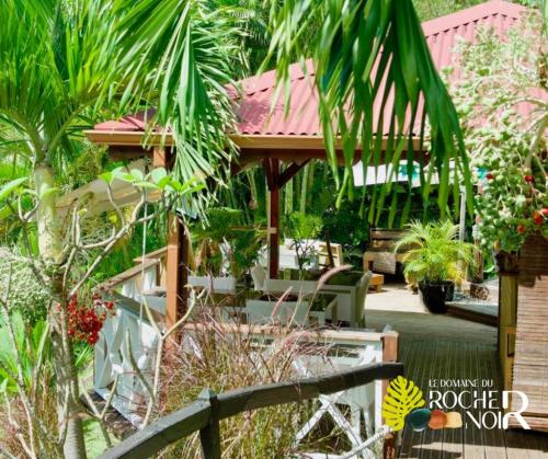 a garden with a gazebo and some plants at Le Domaine du Rocher Noir in Pointe-Noire