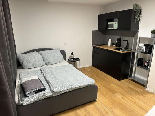 a small bedroom with a bed and a kitchen at Modern living: Stylish one-bedroom flat in Hockenheim