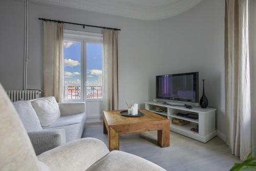 ein Wohnzimmer mit einem TV und einem Tisch in der Unterkunft Hostal Besaya in Madrid