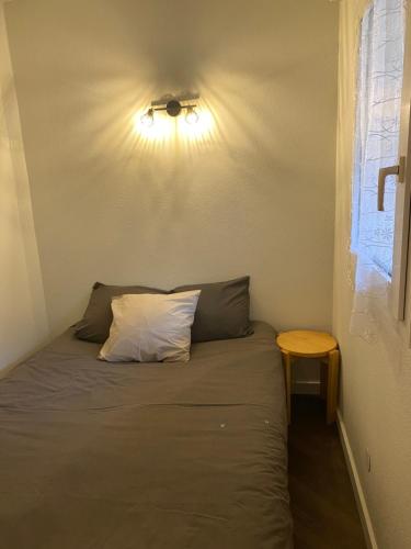a bed with a pillow and a table in a room at La Tarentaise. in Brides-les-Bains