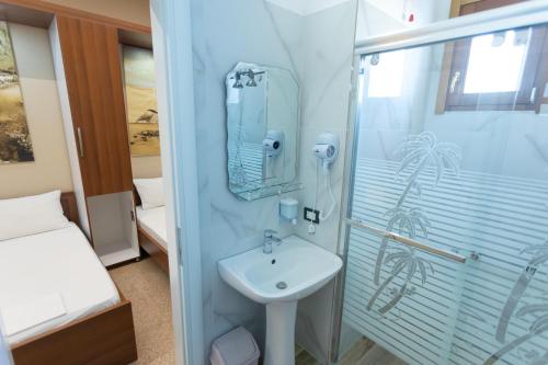un bagno con lavandino e doccia di Vila Kaci a Durrës