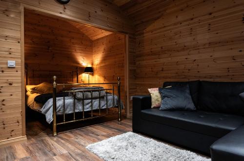 ein Schlafzimmer mit einem Bett und einem Sofa in einem Zimmer in der Unterkunft The Hen Harrier - 4 Person Luxury Glamping Cabin in Dungarvan