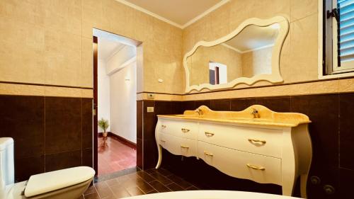 W łazience znajduje się umywalka i lustro. w obiekcie Click&Guest - Blue Marine in Playa del Hombre w mieście Telde