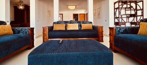 salon z niebieskimi krzesłami i otomaną w obiekcie Click&Guest - Blue Marine in Playa del Hombre w mieście Telde