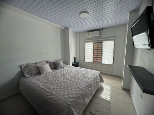 Schlafzimmer mit einem Bett und einem Flachbild-TV in der Unterkunft Casa En Leticia in Leticia