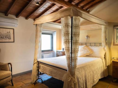 ein Schlafzimmer mit einem Himmelbett in einem Zimmer in der Unterkunft Villa Peramonda in Fiesole