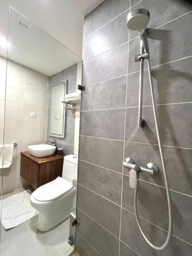 a bathroom with a shower with a toilet and a sink at FOREST VIEW LUXURY APARTMENT in 3mins walk to beach pool view wifi in Kololi