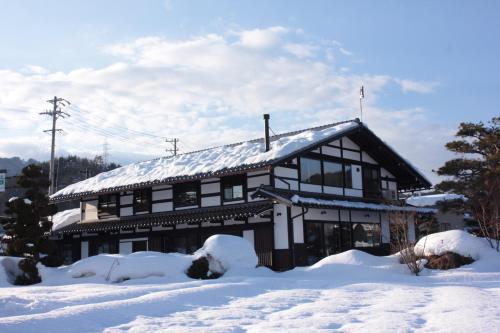 a building with snow on the roof in the snow at SOY in Takayama
