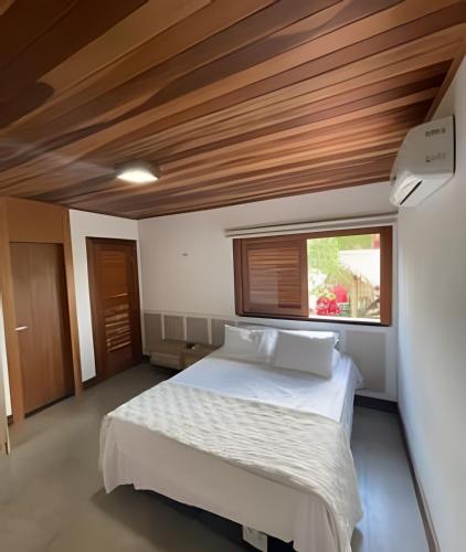 ein Schlafzimmer mit großem Bett und Fenster in der Unterkunft Casa confortável em condomínio in Barra Grande