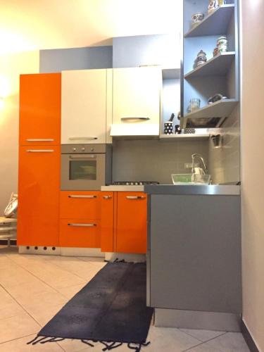 een keuken met oranje kasten en een wastafel bij A due passi dal mare in Loano