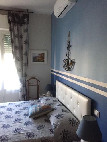 een slaapkamer met een bed met een blauwe muur bij A due passi dal mare in Loano