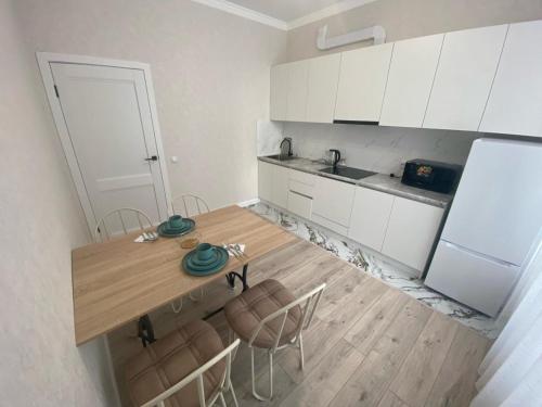 kuchnia ze stołem, krzesłami i lodówką w obiekcie Apartaments COSTA ЖК Тандау w mieście Astana