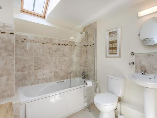 a bathroom with a tub and a toilet and a sink at 4 Bed in Brixham BX072 in Brixham