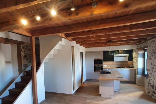 a kitchen with a counter and a staircase in a room at Au coin des amis in Aurillac