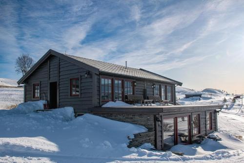 una casa pequeña cubierta de nieve en Rondane Haukliseter Fjellhotell, en Høvringen
