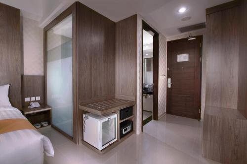 a bedroom with a bed and a tv in a room at Aston Lampung City Hotel in Bandar Lampung