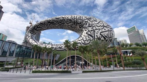un bâtiment avec une arche métallique dans une ville dans l'établissement White Moon Men's Hostel, à Dubaï