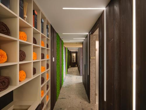 a hallway with a wall of shelves with orange foods at Collina Luxury Relais in Clusone