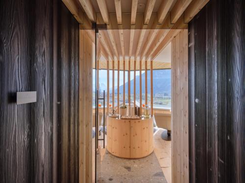 a room with wooden walls and a large window at Collina Luxury Relais in Clusone